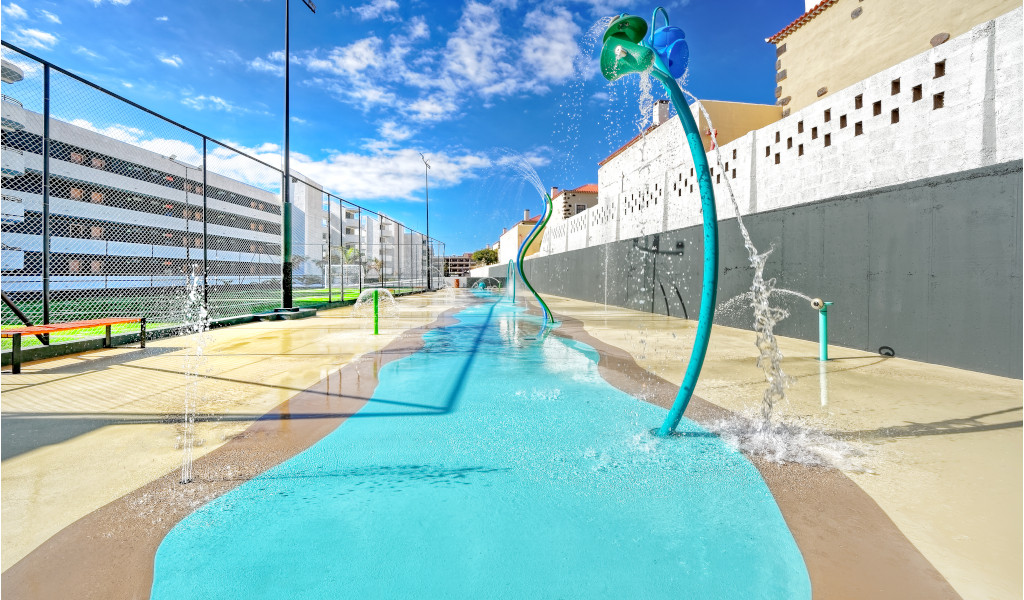 Wasserspielplatz mit Springbrunnen in Costa Adeje, Tenerife und blühender Pflanzenskulptur.