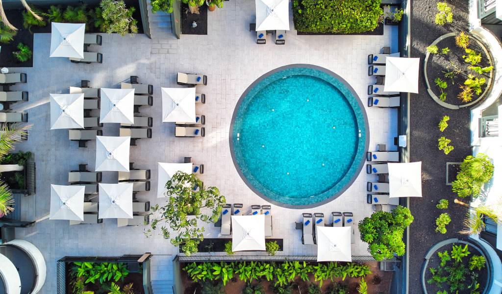 Runder Pool mit Sonnenschirmen und Liegestühlen in einem Hotel in Tenerife.