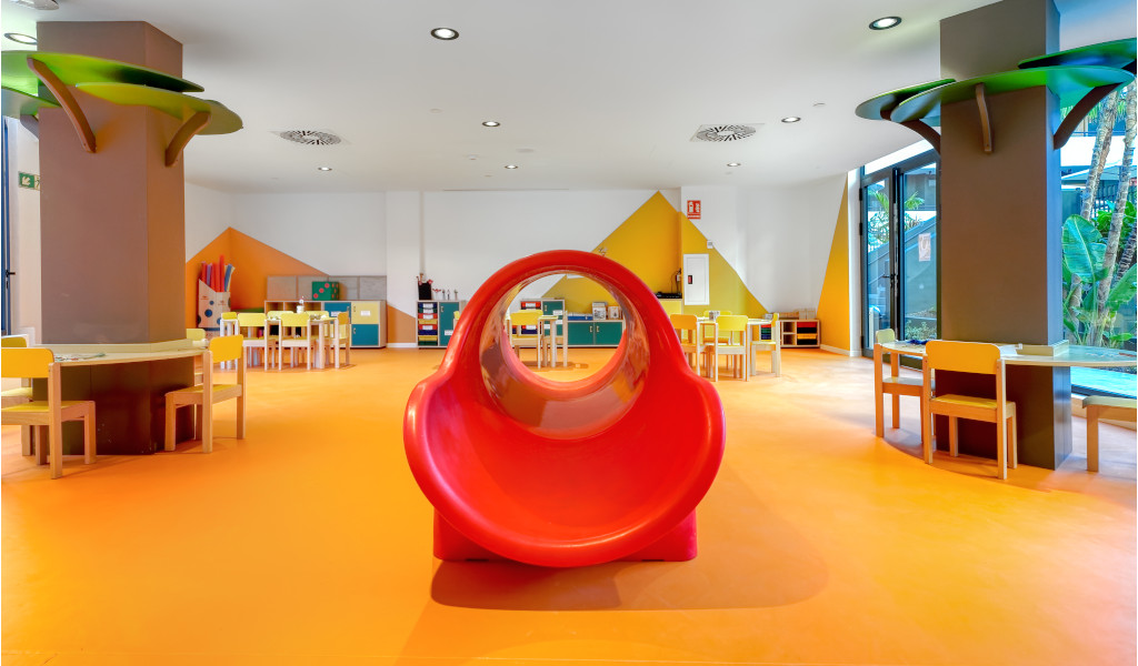 Innenansicht eines Kinderspielzimmers mit roten Rutschen und Tischen in Puerto de la Cruz.