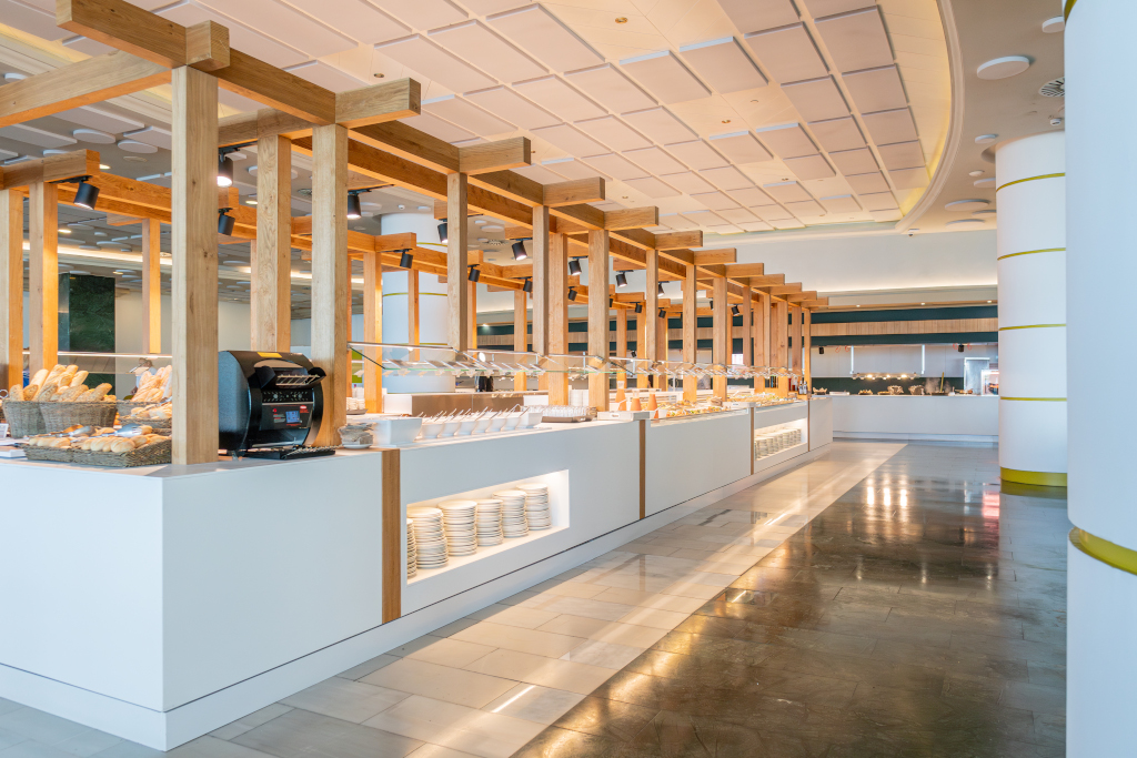 Buffet in einem modernen Restaurant in Tenerife mit Tellern und Brot.