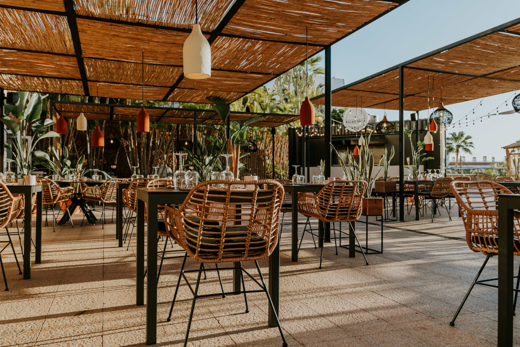 Terrasse eines Restaurants in Tenerife mit Korbstühlen und Pflanzen.