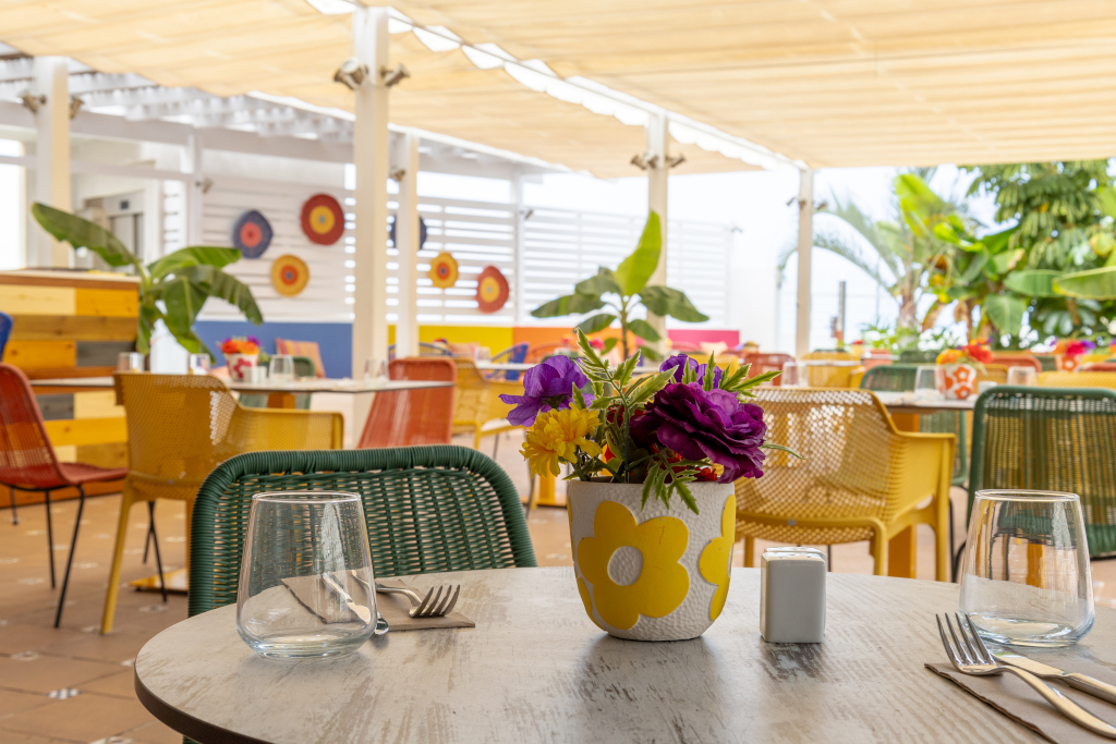 Bunter Außenbereich eines Restaurants in Costa Adeje mit Blumen auf dem Tisch.