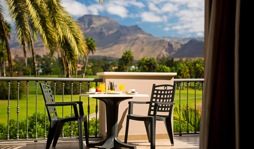 Terrasse mit Tisch, Stühlen, Frühstück und Blick auf Berge in Teneriffa.