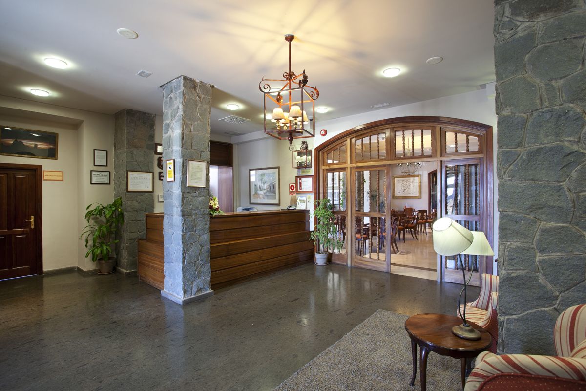 Empfangsbereich eines Hotels in Tenerife mit Rezeption und Sitzecke.