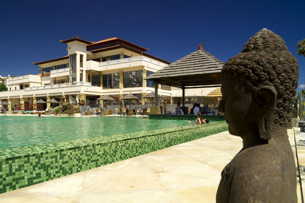 Poolbereich mit Buddha-Statue vor asiatischem Gebäude in Tenerife.