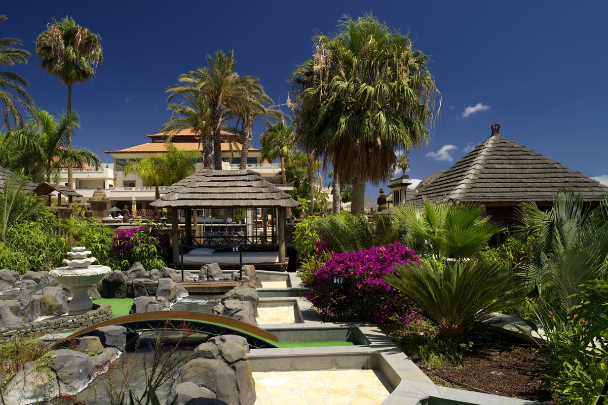 Garten mit Palmen und Wasserläufen in einem Resort auf Teneriffa.