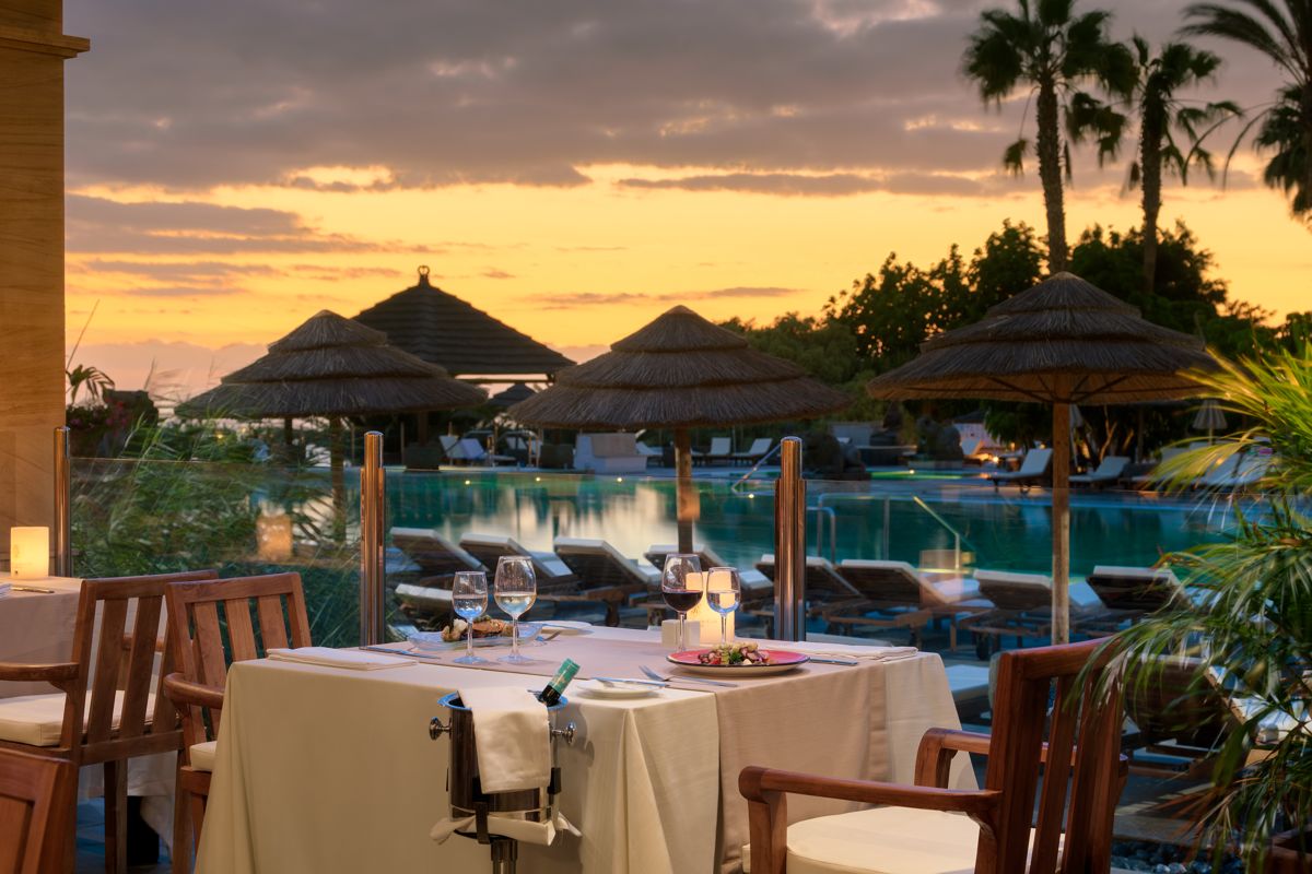 Eindecken Tisch mit Blick auf Sonnenuntergang und Pool in Teneriffa.