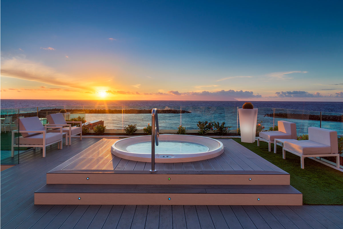 Jacuzzi auf einer Terrasse mit Blick auf Sonnenuntergang am Meer in Tenerife.