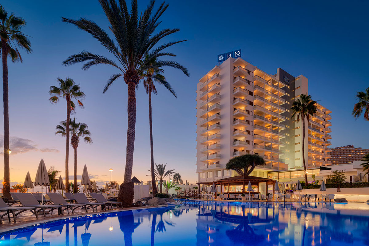 Hotelgebäude bei Sonnenuntergang neben Pool in Playa de las Américas, Teneriffa.