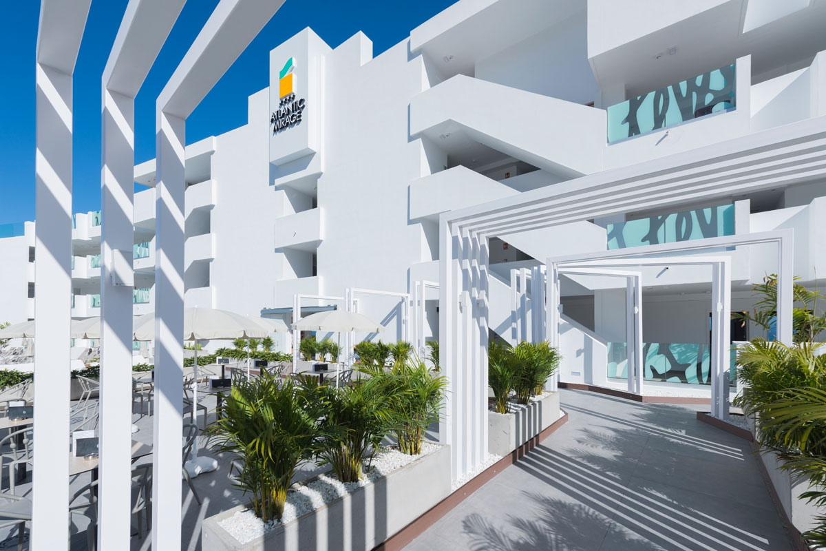 Modernes weißes Gebäude von Atlantic Mirage in Tenerife mit Pflanzen und Terrassenmöbeln.