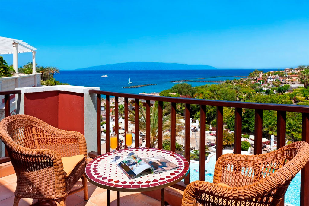 Blick von der Terrasse auf das Meer in Costa Adeje, Teneriffa, mit Segelboot und Cocktail.
