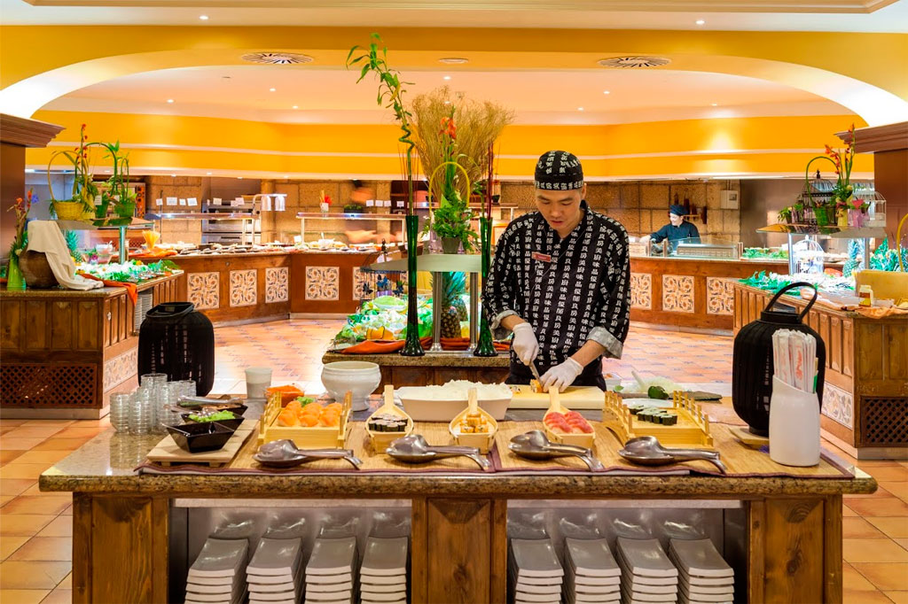 Koch bereitet Sushi an Buffetstation in Restaurant in Puerto de la Cruz zu.