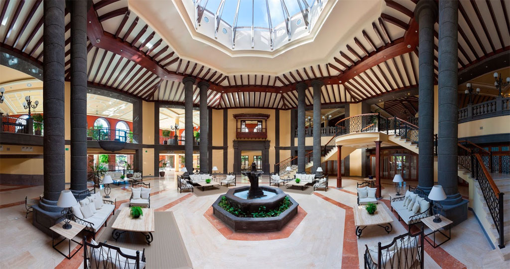 Großes, luxuriöses Hotelatrium in Teneriffa mit Sofas, Tischen und eleganten Säulen.
