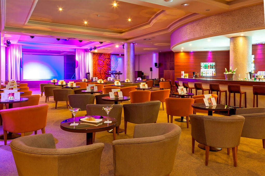 Gemütliche Bar mit Tischen und Stühlen, beleuchtet von bunten Lichtern in Costa Adeje.
