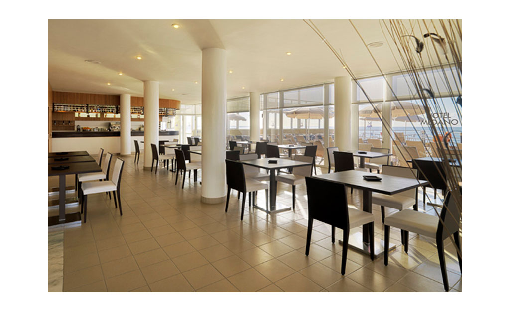 Offenes Restaurant in Hotel am Meer in Teneriffa. Tische und Stühle im Innenbereich.