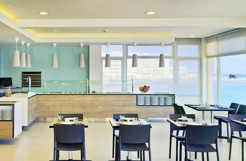 Innenraum eines Restaurants in Teneriffa mit Meerblick und gedeckten Tischen.
