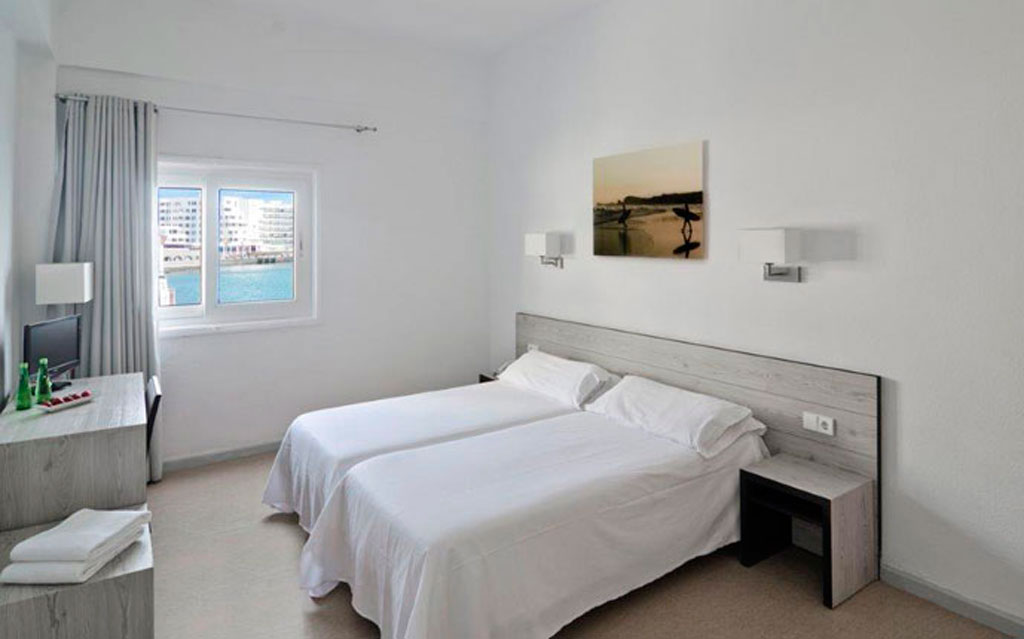 Zimmer mit zwei Einzelbetten und Fensterblick auf Los Cristianos, Teneriffa.