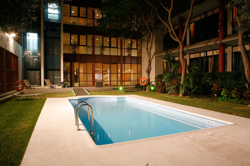 Pool mit Liegestühlen und Pflanzen im Innenhof eines Hotels in Santa Cruz de Tenerife.
