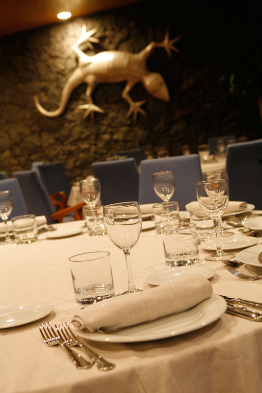 Elegantes Tischdecken und Besteck in einem Restaurant in Tenerife, Wanddekoration einer Eidechse.