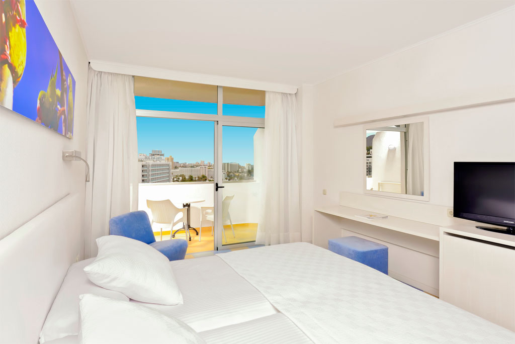 Helles Hotelzimmer mit Balkonblick auf Costa Adeje, Teneriffa.