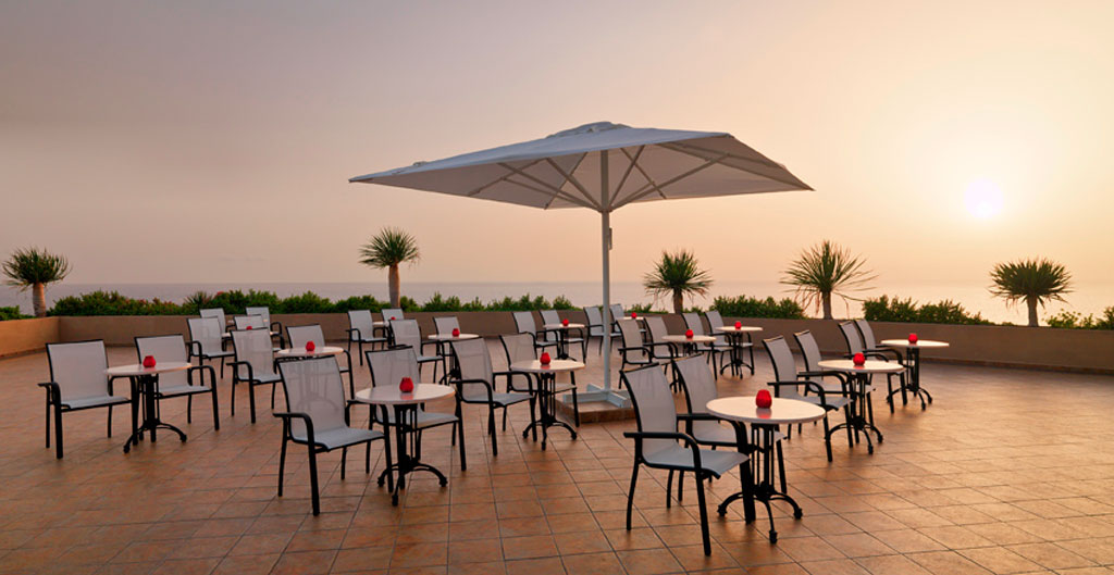 Sonnenuntergang über einer Terrasse mit Tischen und Stühlen in Tenerife.