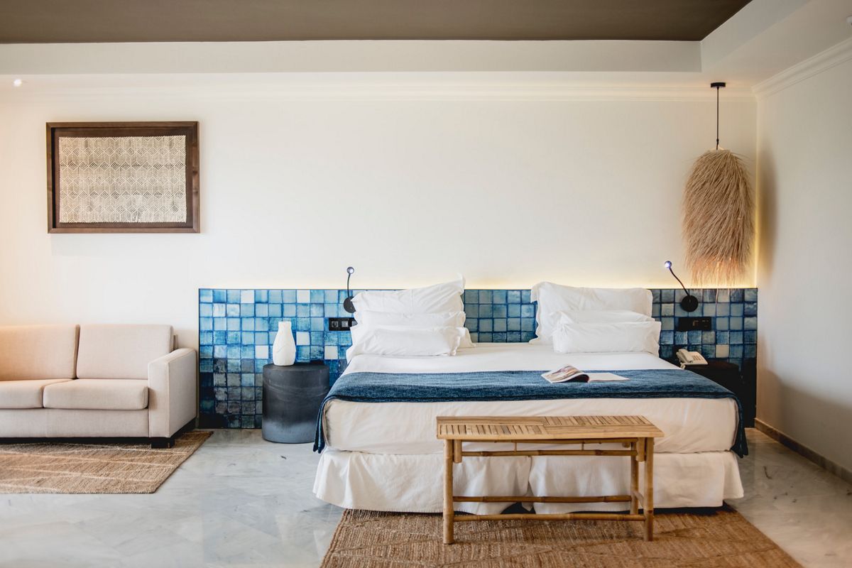 Gemütliches Hotelzimmer mit Doppelbett, Couch und blauer Fliesenwand in Tenerife.