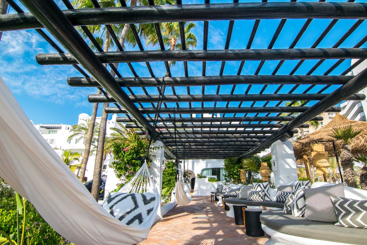 Hängematten und Sitzbereich unter Pergola in Hotel auf Teneriffa.