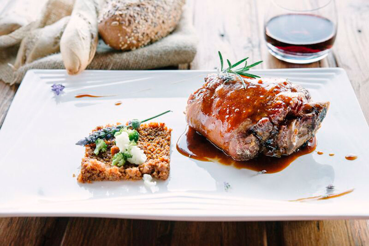 Gourmetgericht mit Soße, Brot und Rotwein in einem Restaurant in Teneriffa.
