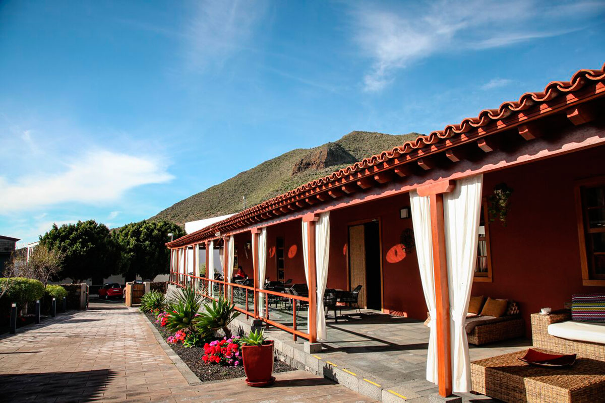 Langes Gebäude mit Terrasse vor Berg in Teneriffa.