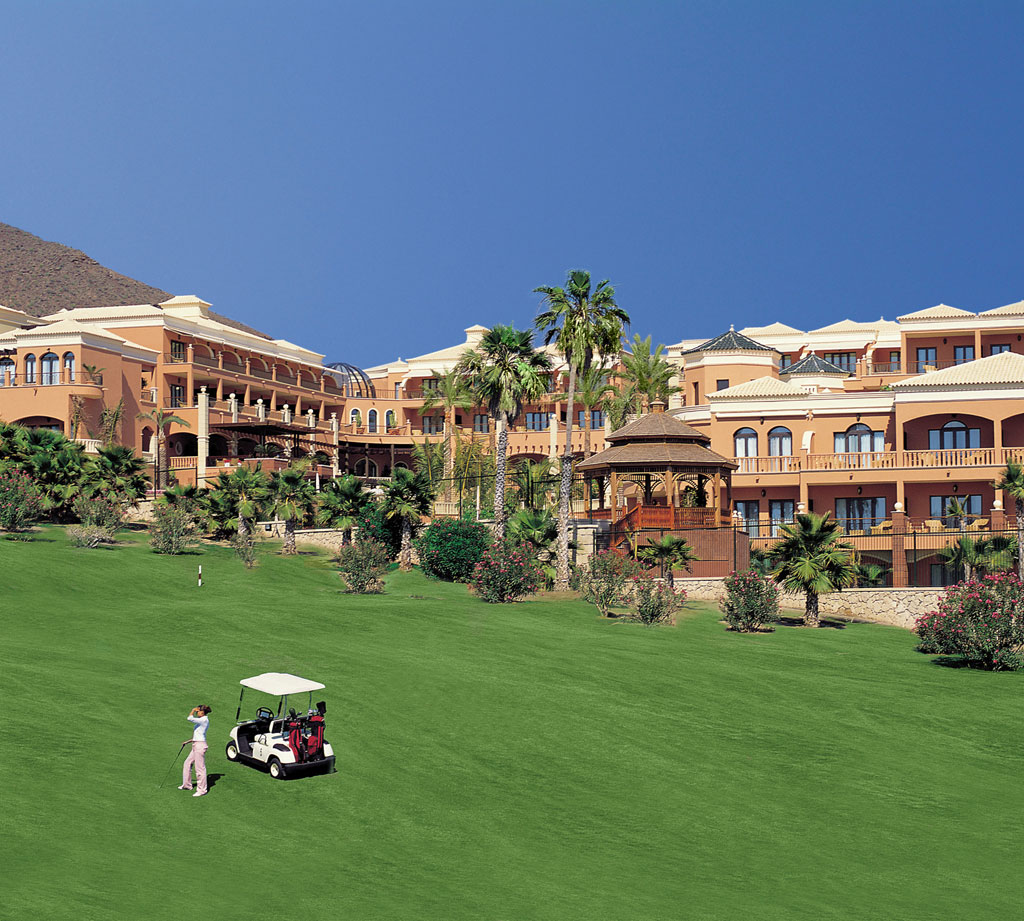 Golfer spielt auf Rasen vor großem Hotel in Teneriffa.
