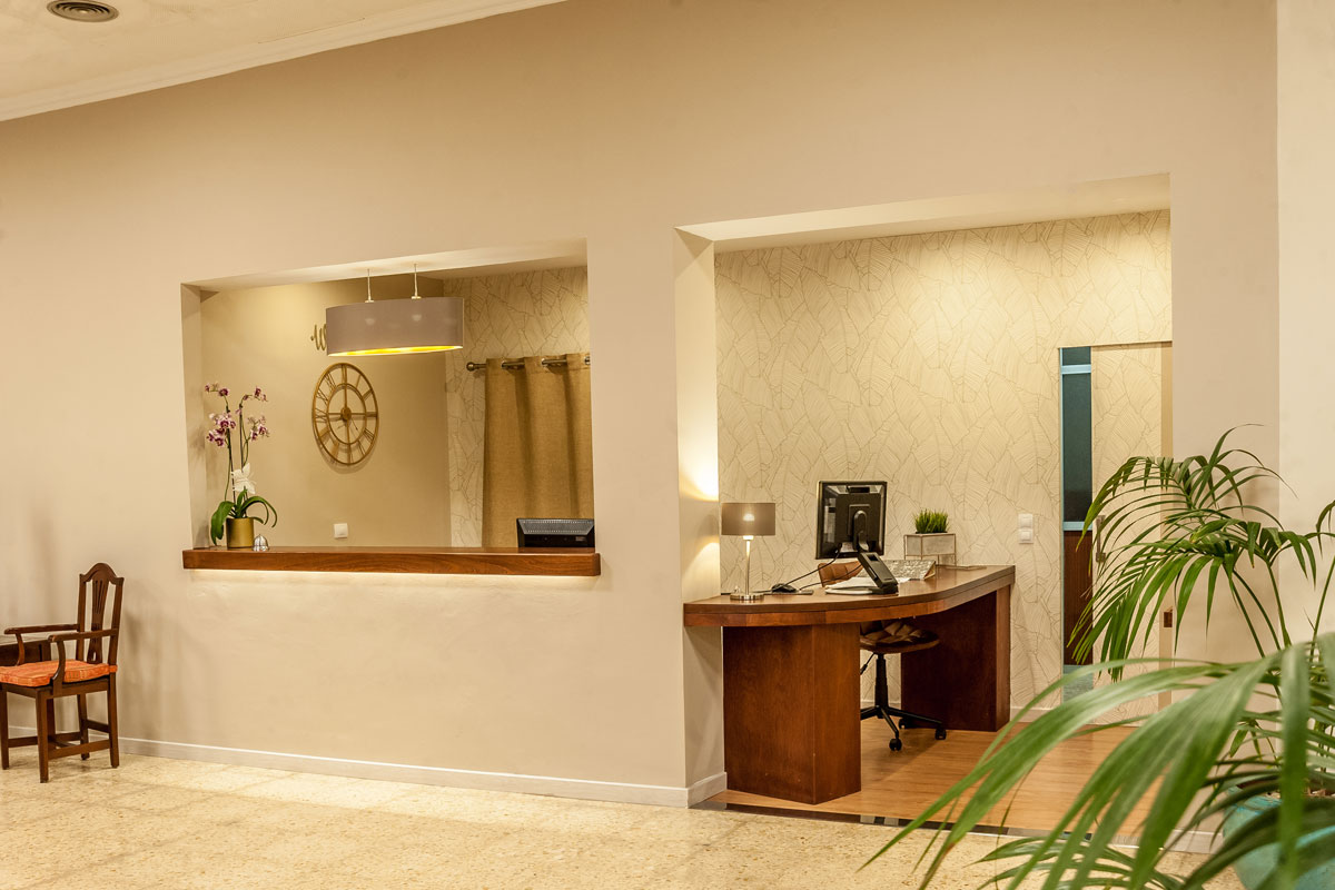 Rezeption mit Schreibtisch, Stuhl, Computer und Pflanze in Hotel in Puerto Cruz, Teneriffa.