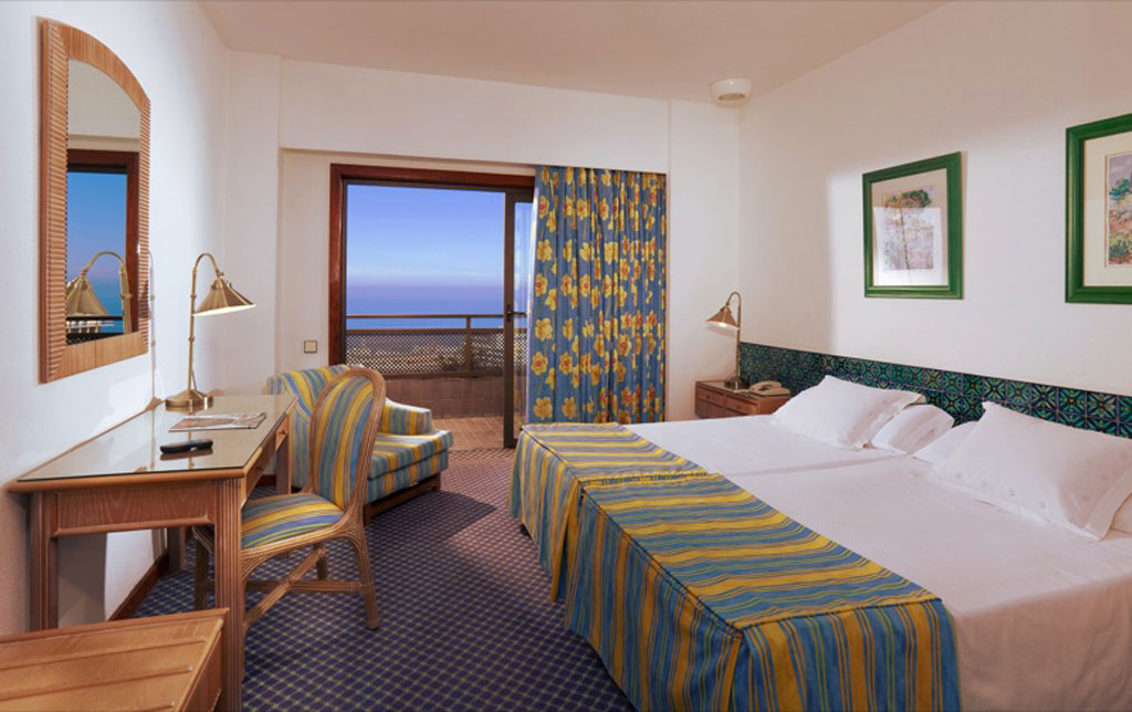 Zweibettzimmer mit Meerblick, Balkon und Möbeln in Teneriffa.