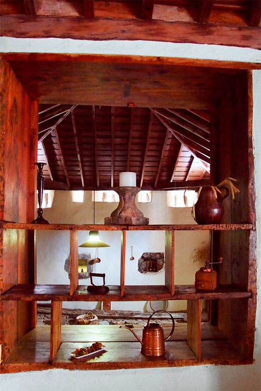 Rustikales Holzregal mit Kerzen und Gefäßen im traditionellen Haus in Tenerife.
