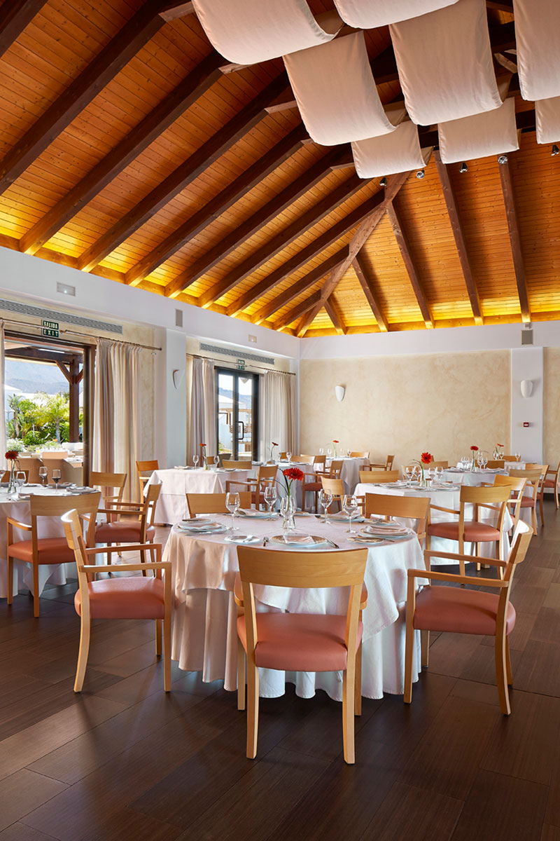 Rund gedeckte Tische in einem Restaurant in Teneriffa mit Holzdecke.
