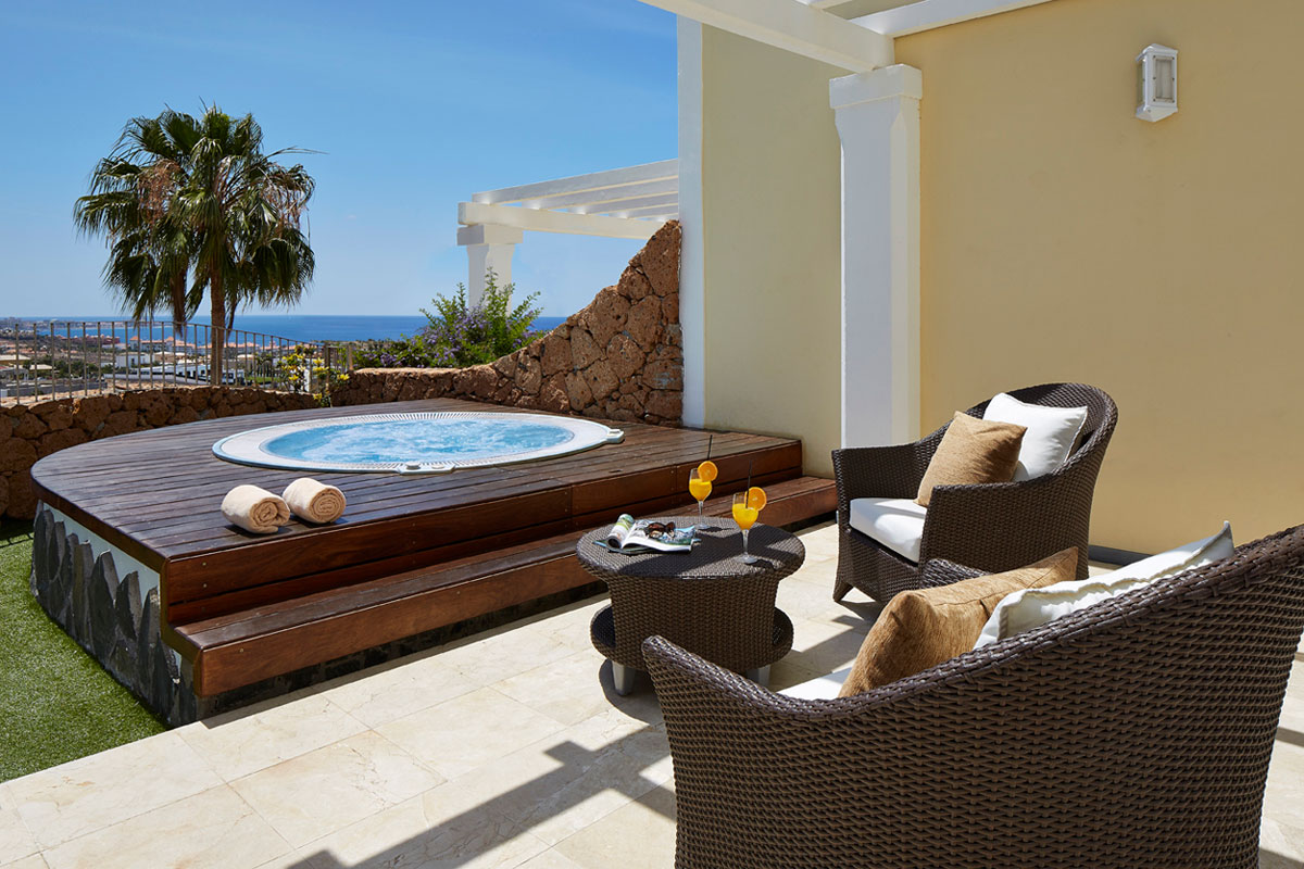 Whirlpool-Terrasse mit Meerblick in Costa Adeje, Teneriffa, zwei Cocktails auf Tisch.