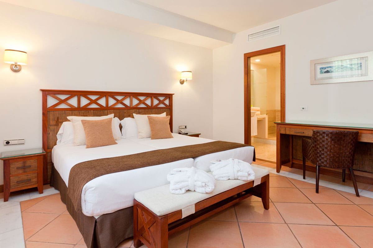 Hotelzimmer mit Doppelbett in Costa Adeje, Tenerife. Schreibtisch und Badezimmer sichtbar.