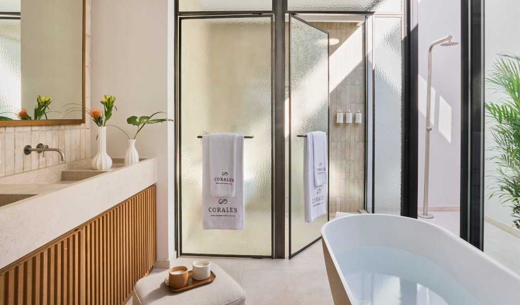 Modernes Badezimmer mit Badewanne, Glasdusche und Handtüchern im Corales Resort, Teneriffa.