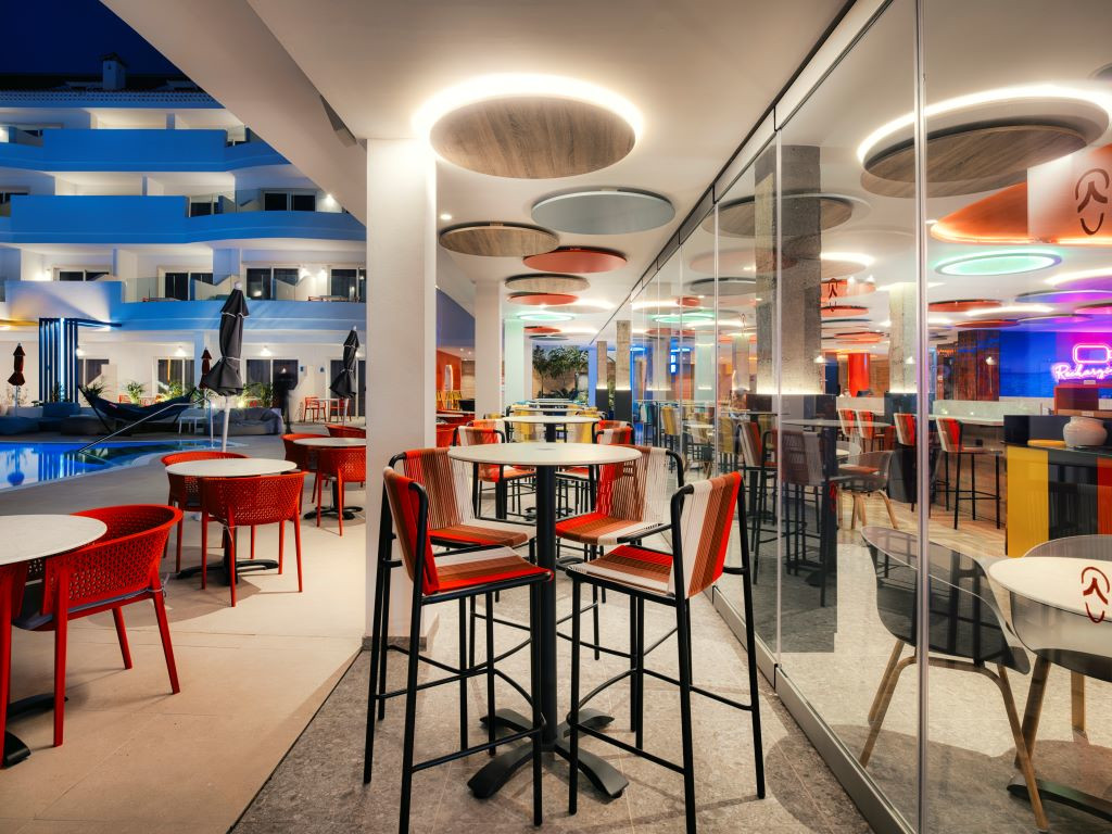 Terrasse eines Restaurants mit roten Tischen und Stühlen in einem Hotel auf Teneriffa nachts.