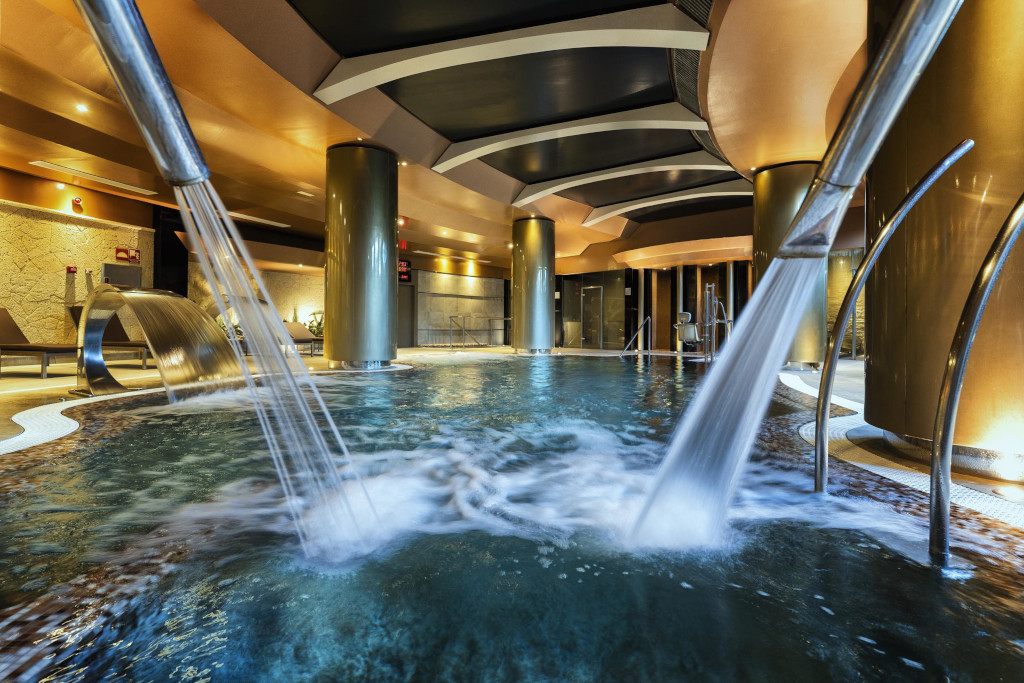 Innenpool im Spa-Bereich eines Hotels in Adeje, Teneriffa, mit laufenden Wasserstrahlen.