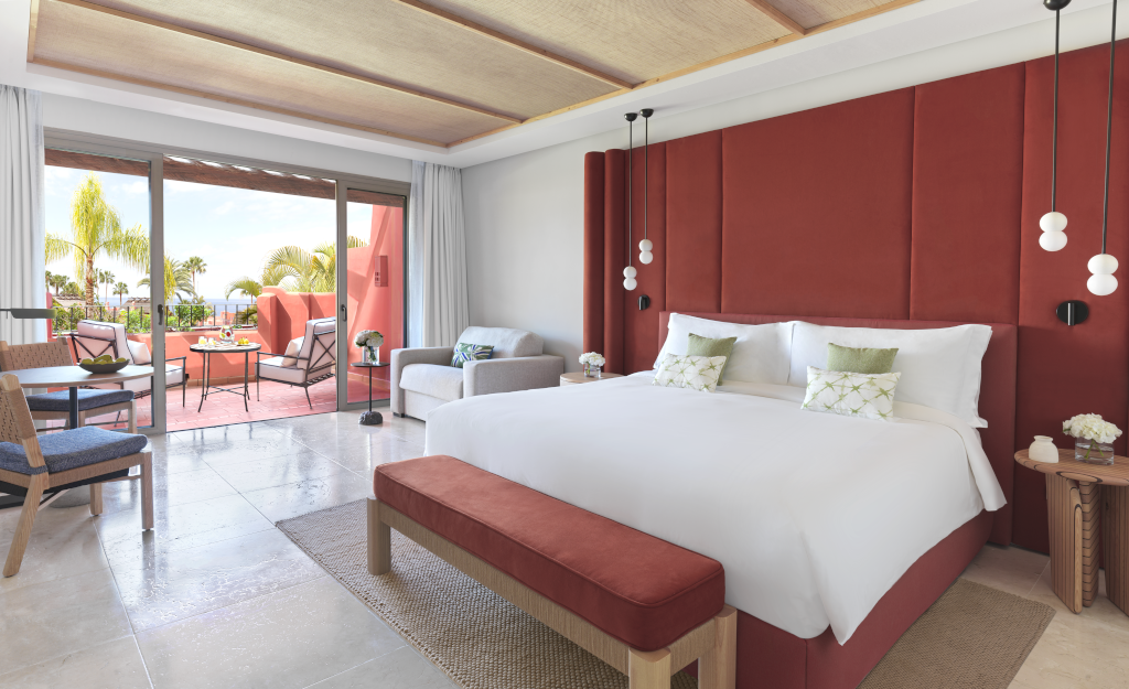 Modernes Hotelzimmer in Teneriffa mit Balkonmöbeln und Palmenblick.