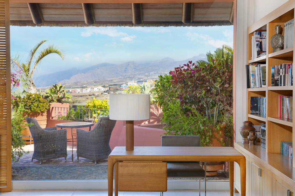 Blick von einem Büro auf eine Terrasse mit Pflanzen und Bergen in Adeje, Teneriffa.