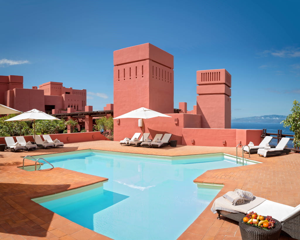 Sonnenliegen und Poolterrasse im Hotel auf Teneriffa mit Meerblick.