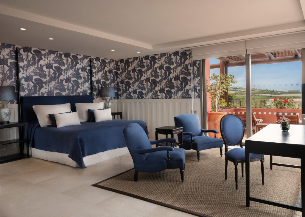 Geräumiges Hotelzimmer mit blauer Einrichtung und Balkonblick in Teneriffa.