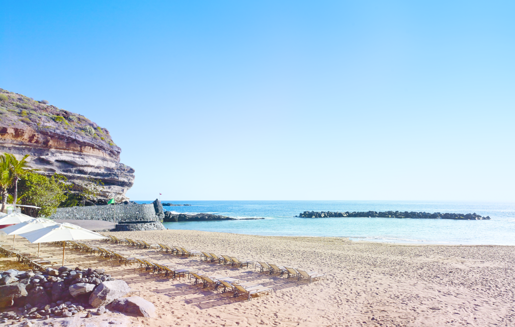 Strand mit Liegestühlen und Klippen in Costa Adeje, Teneriffa.