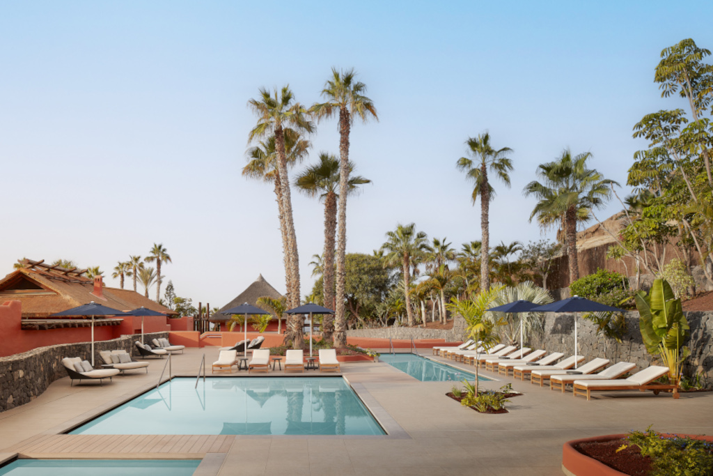 Außenpool mit Liegestühlen und Palmen im Hotel in Teneriffa.