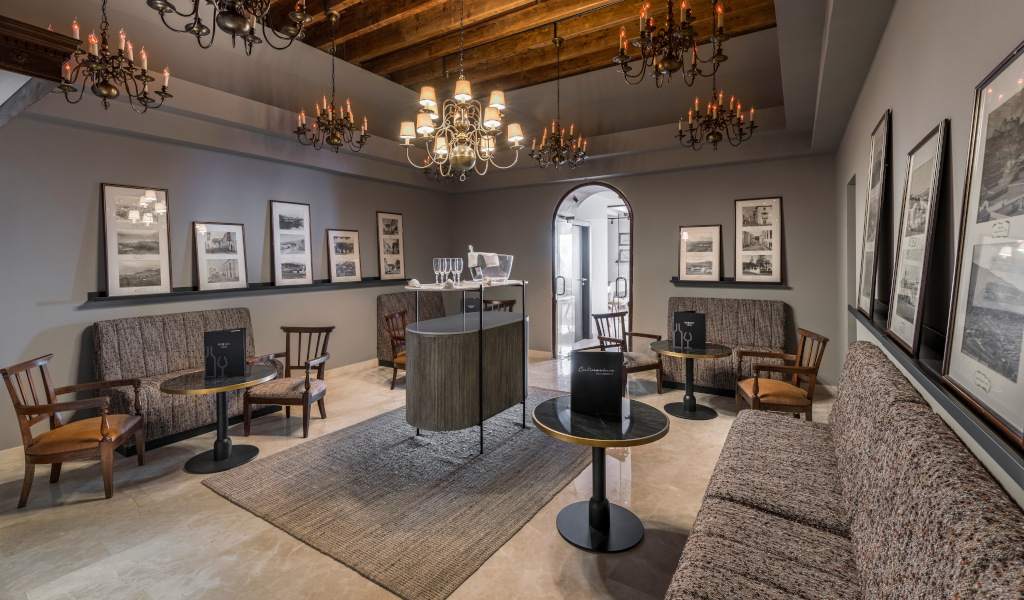 Weinverkostungsraum mit Sofas, Tischen und Fotos an der Wand in einem Gebäude auf Teneriffa.