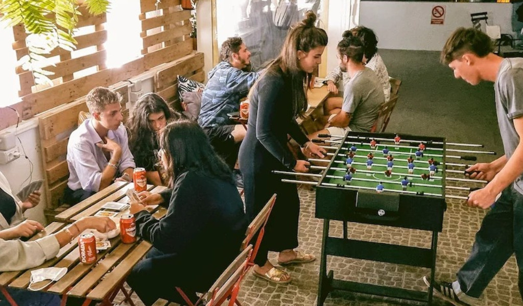 Personen spielen Tischfußball und Karten in einem Café auf Teneriffa.