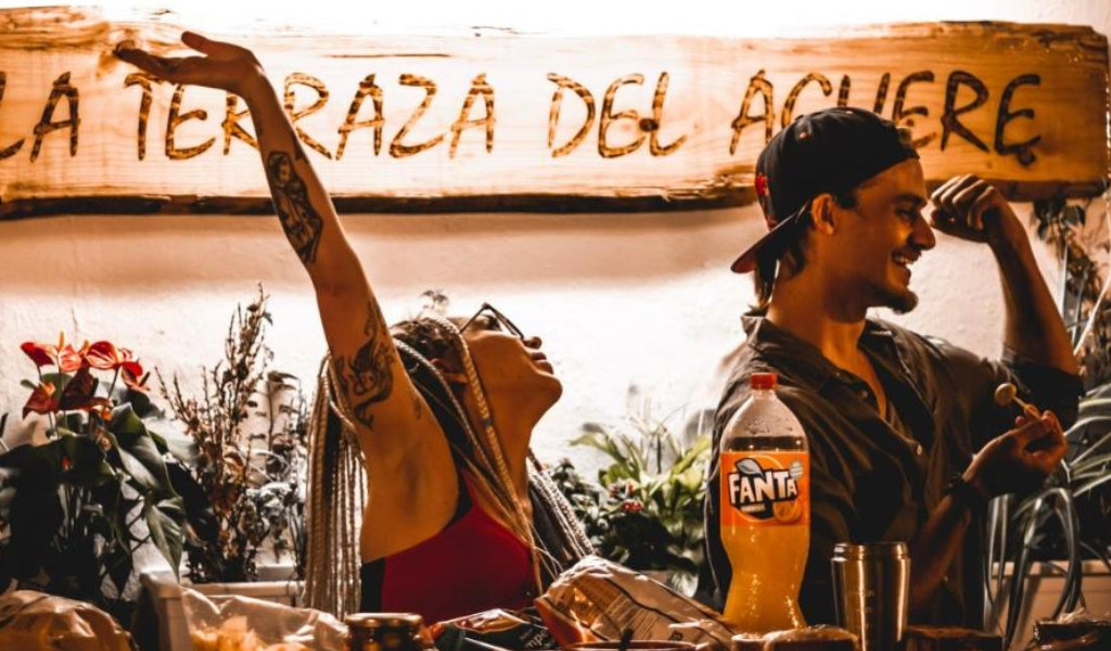 Zwei Personen in der La Terraza del Achere mit einer Fanta-Flasche.