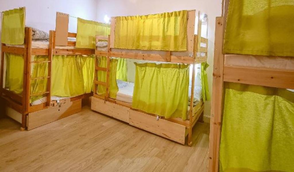 Vier Etagenbetten mit grünen Vorhängen in einem Raum in Tenerife.