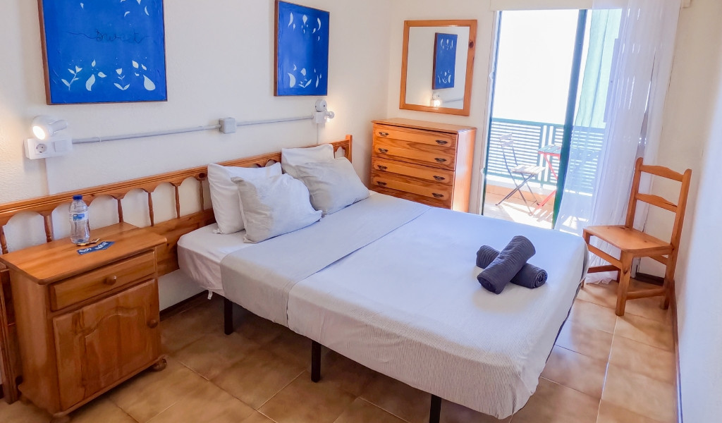 Schlafzimmer in Teneriffa mit Doppelbett, Nachttisch, Spiegel und Balkon.